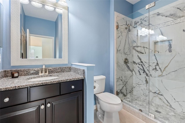 bathroom with a shower with door, vanity, toilet, and tile patterned floors