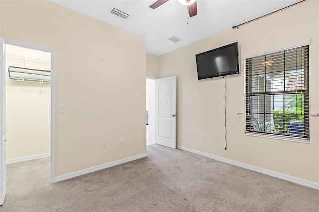 unfurnished bedroom featuring light carpet, a closet, and ceiling fan