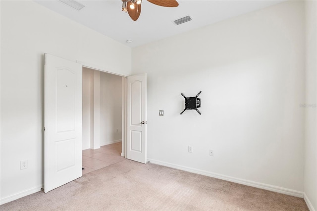 spare room featuring light colored carpet and ceiling fan