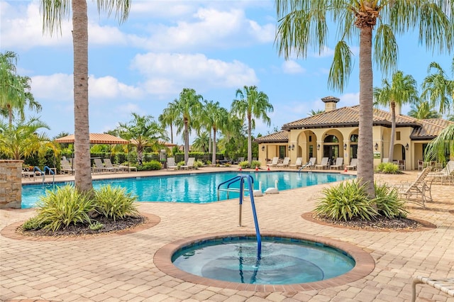 view of swimming pool with a patio area and a community hot tub