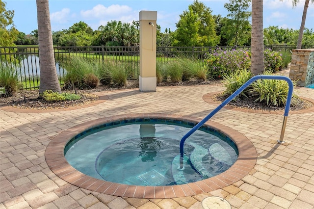 view of pool featuring a patio area, an in ground hot tub, and a water view