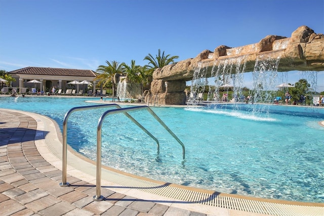 view of swimming pool with pool water feature