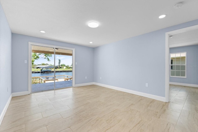 6912 Kenwood Dr, North Port, FL 34287 - unfurnished room featuring a smoke detector, baseboards, a water view, and recessed lighting