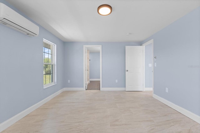 empty room with a wall mounted air conditioner and baseboards