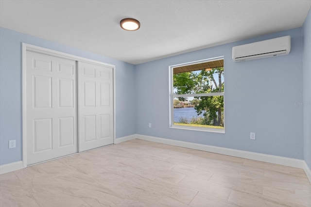 6912 Kenwood Dr, North Port, FL 34287 - unfurnished bedroom featuring a wall mounted air conditioner, baseboards, and a closet