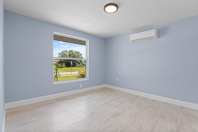 unfurnished room featuring a wall unit AC and baseboards