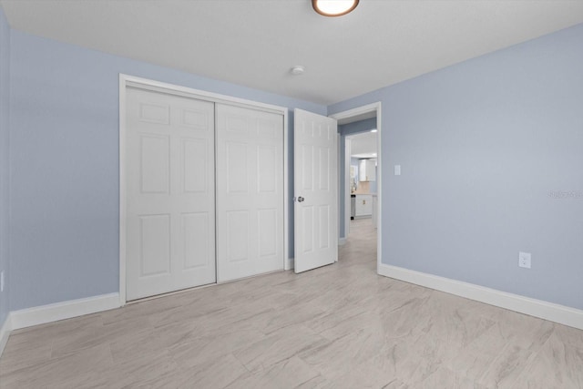 unfurnished bedroom featuring a closet and baseboards