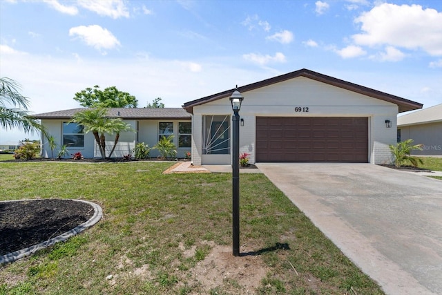 ranch-style home with a garage, a front yard, concrete driveway, and brick siding