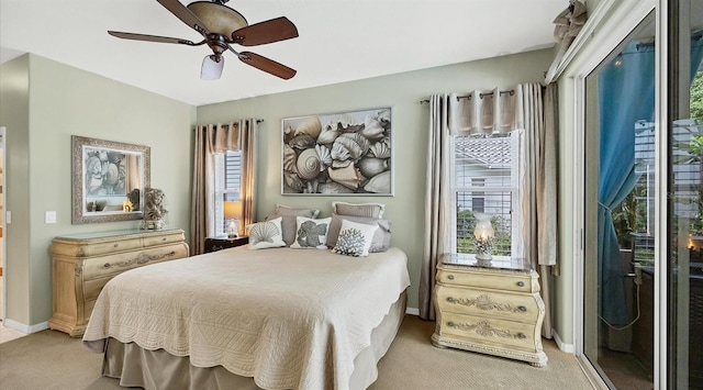 bedroom featuring access to outside, light colored carpet, multiple windows, and ceiling fan