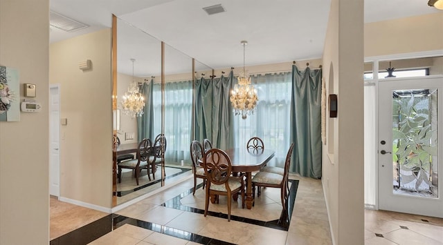 dining room with light tile patterned floors and an inviting chandelier