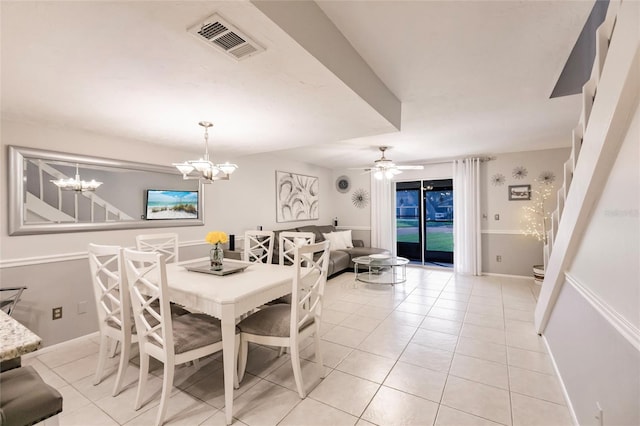 tiled dining room featuring ceiling fan with notable chandelier