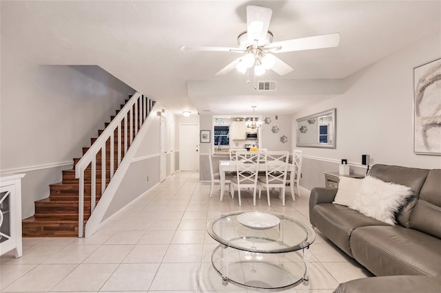 living room featuring light tile patterned flooring and ceiling fan with notable chandelier