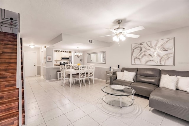 living room featuring ceiling fan with notable chandelier and light tile patterned floors