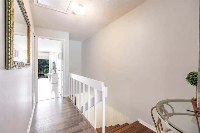 hallway featuring hardwood / wood-style flooring and a textured ceiling