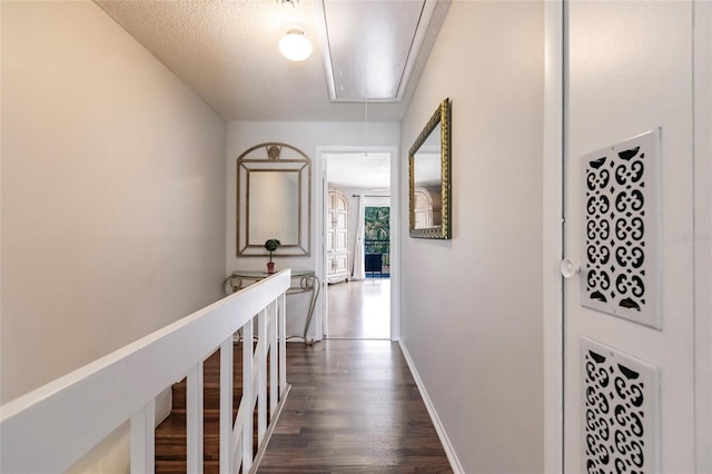 hallway with a textured ceiling and dark wood-type flooring