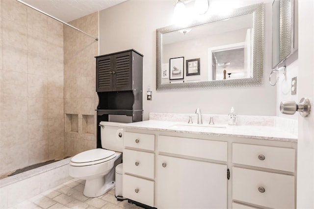 bathroom featuring tiled shower, vanity, and toilet