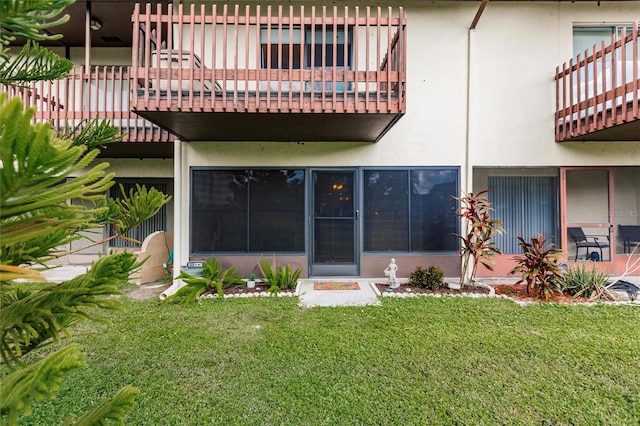 back of house featuring a yard and a balcony