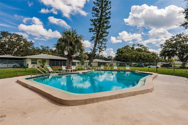 view of swimming pool with a yard and a patio area