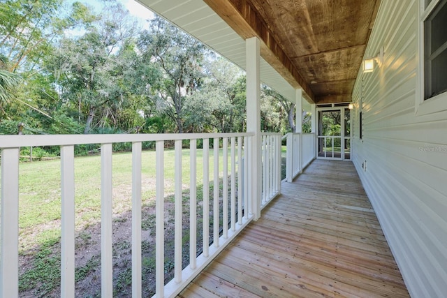 wooden terrace with a porch and a lawn