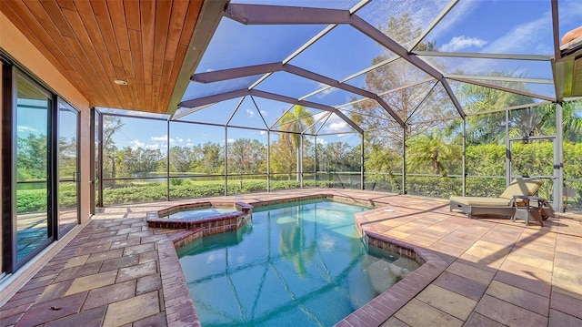 view of swimming pool with a pool with connected hot tub, a lanai, and a patio area