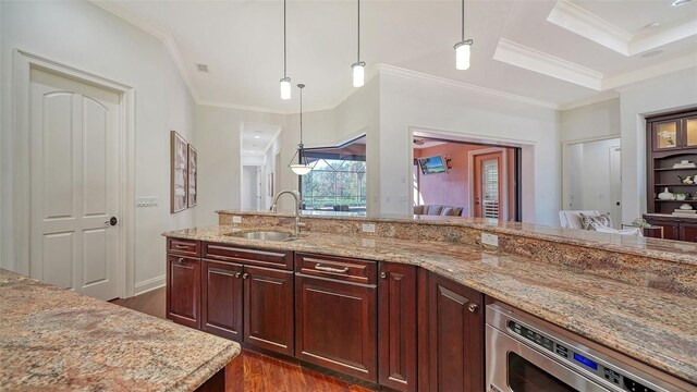 kitchen featuring crown molding, sink, pendant lighting, and dark hardwood / wood-style flooring