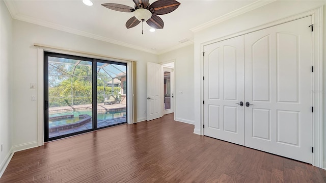 unfurnished bedroom featuring access to outside, a closet, dark wood-type flooring, ornamental molding, and ceiling fan