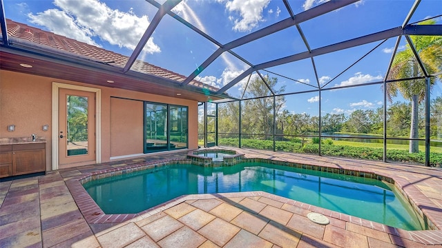 view of pool featuring an in ground hot tub, a patio area, and a lanai