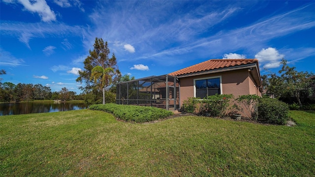 view of yard with a water view and glass enclosure