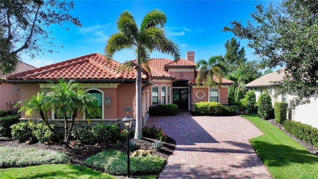 mediterranean / spanish house featuring a tiled roof, french doors, and stucco siding