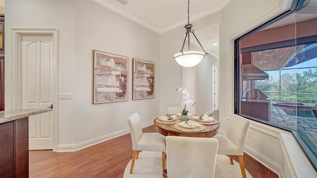 dining room featuring crown molding, baseboards, and light wood-style floors