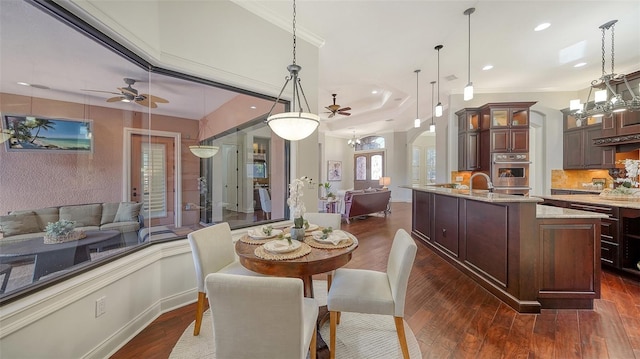 dining room featuring dark wood-type flooring, recessed lighting, ceiling fan, and arched walkways