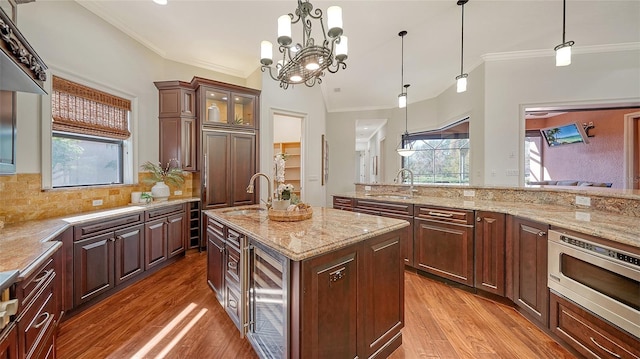 kitchen featuring crown molding, stainless steel microwave, a sink, and wine cooler