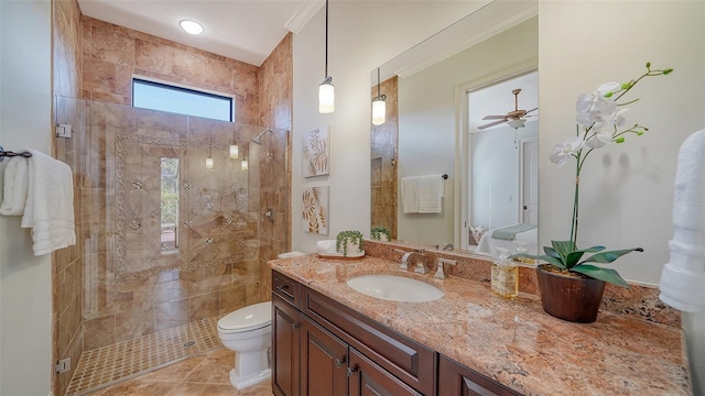 bathroom featuring toilet, tiled shower, and vanity
