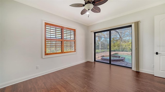 empty room featuring baseboards, ornamental molding, dark wood finished floors, and a ceiling fan