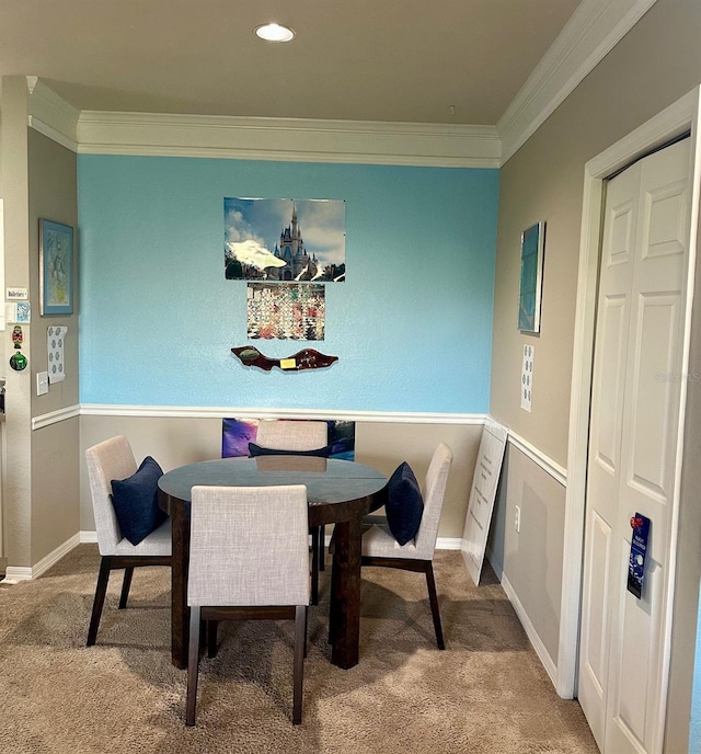 dining room with ornamental molding and carpet