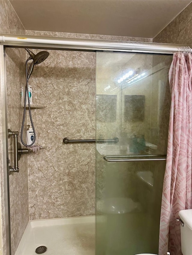 bathroom with toilet and walk in shower