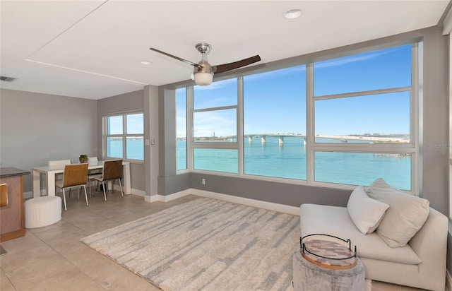 226 Golden Gate Pt Unit 64, Sarasota, FL 34236 - living room featuring light tile patterned floors, a water view, ceiling fan, baseboards, and recessed lighting