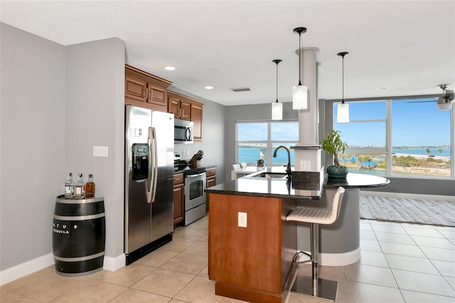226 Golden Gate Pt Unit 64, Sarasota, FL 34236 - kitchen featuring stainless steel appliances, a sink, dark countertops, and light tile patterned flooring