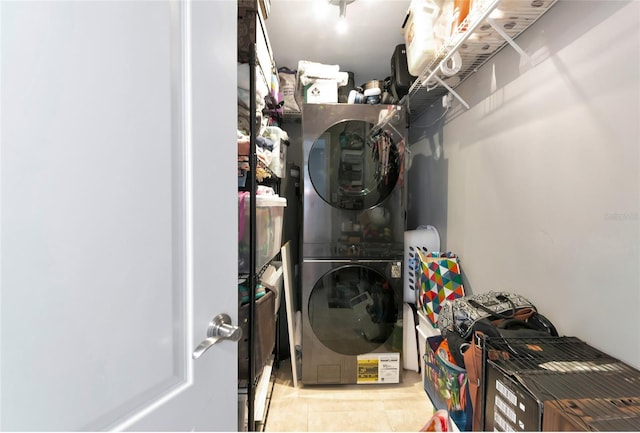 226 Golden Gate Pt Unit 64, Sarasota, FL 34236 - clothes washing area featuring stacked washing maching and dryer, tile patterned floors, and laundry area