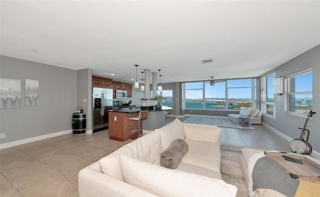 226 Golden Gate Pt Unit 64, Sarasota, FL 34236 - living area featuring light tile patterned flooring, visible vents, baseboards, and a water view