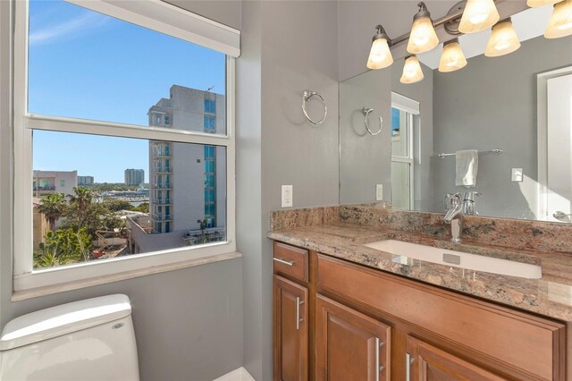 226 Golden Gate Pt Unit 64, Sarasota, FL 34236 - half bathroom with vanity, an inviting chandelier, and toilet