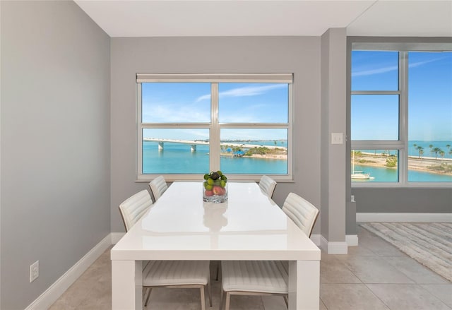 226 Golden Gate Pt Unit 64, Sarasota, FL 34236 - dining space with a water view, baseboards, and light tile patterned floors