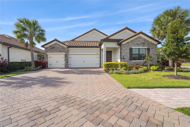 ranch-style home with a garage, stone siding, decorative driveway, a front lawn, and stucco siding