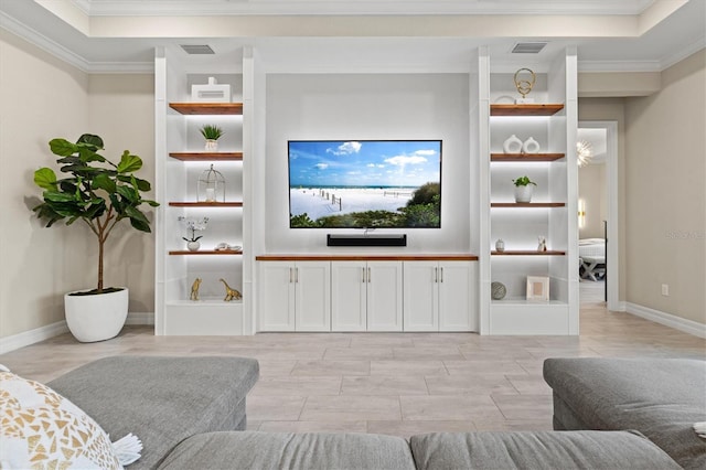 living area featuring baseboards, built in shelves, visible vents, and crown molding