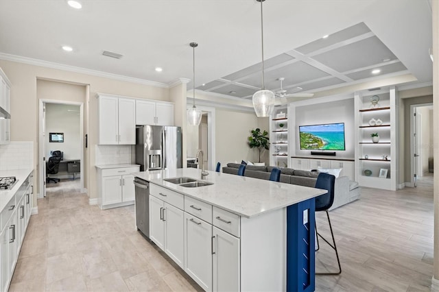 kitchen with stainless steel appliances, coffered ceiling, a sink, and white cabinets