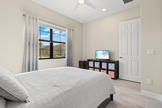 bedroom featuring light wood-style floors, visible vents, baseboards, and a ceiling fan