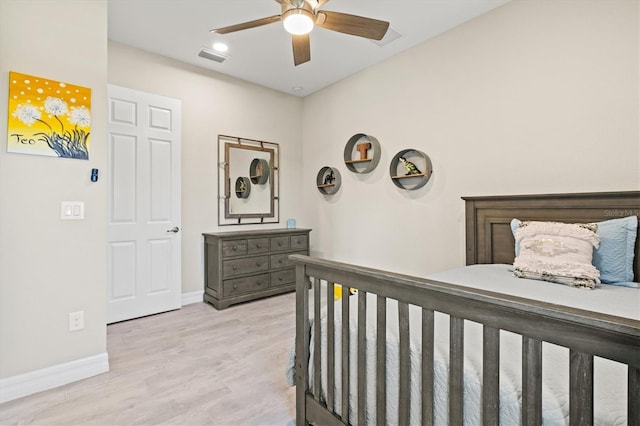 bedroom with baseboards, a ceiling fan, visible vents, and light wood-style floors