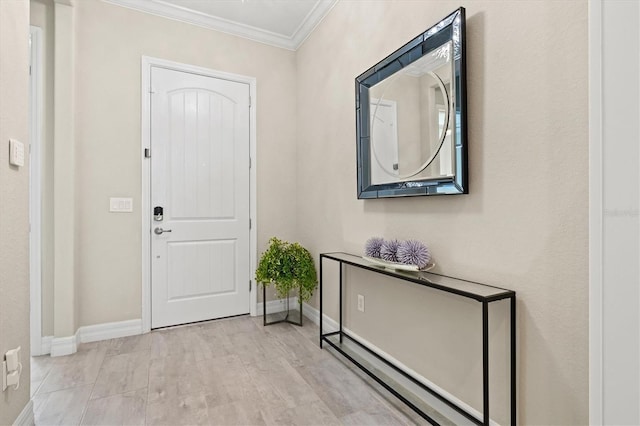 foyer with light wood finished floors, baseboards, and ornamental molding