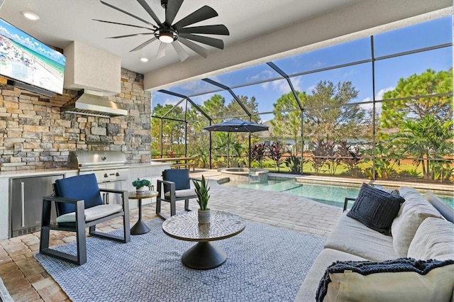 view of patio with an outdoor kitchen, a ceiling fan, area for grilling, a lanai, and a pool with connected hot tub