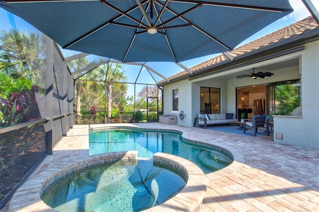 view of pool with ceiling fan, a lanai, outdoor lounge area, a pool with connected hot tub, and a patio area